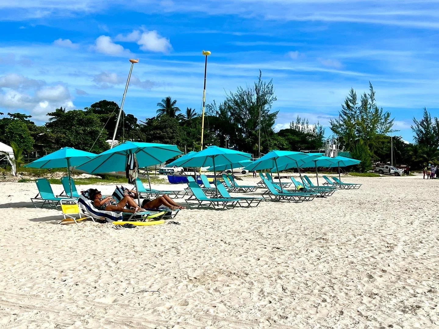 A line of turquoise loungers and umbrellas along the beach at Savvy on the Bay