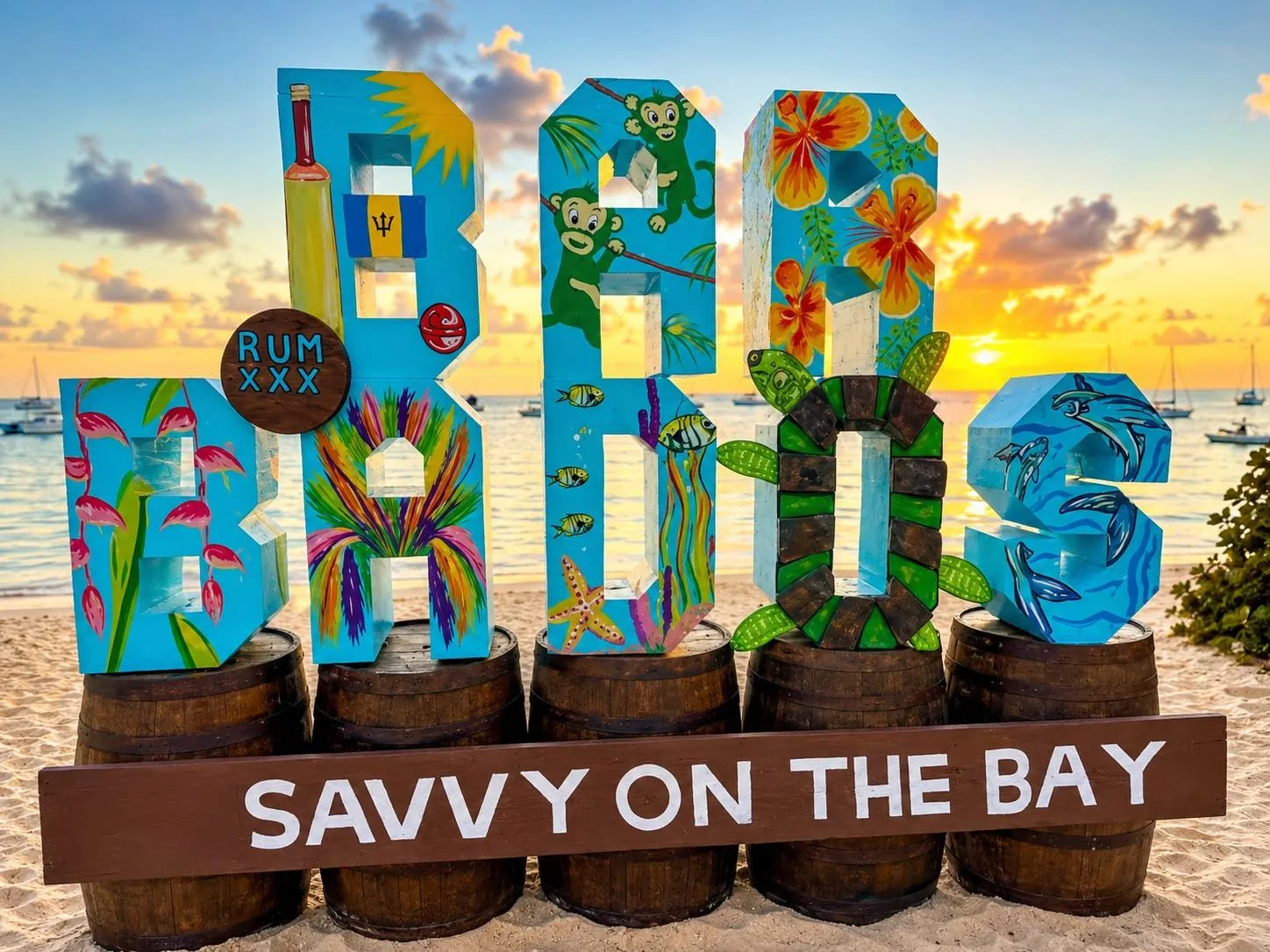 The painted BARBADOS letters on rum barrels at Savvy on the Bay, lit by the sunset behind them